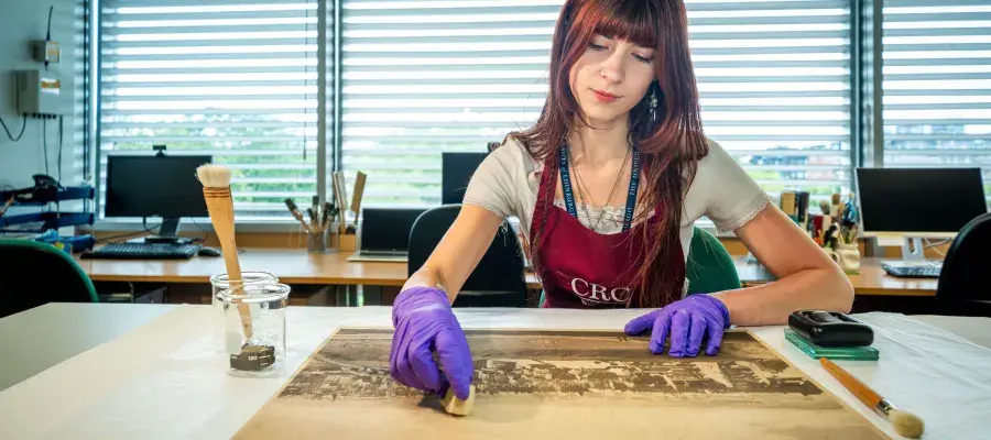This image shows a student cleaning a collection item.