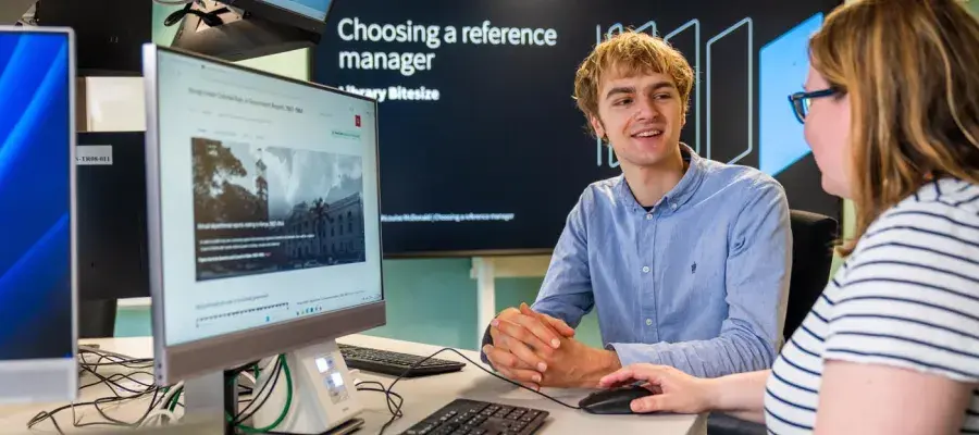 Student and member of staff using a computer for research