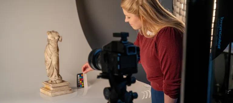 This image shows a member of staff photographing collections.