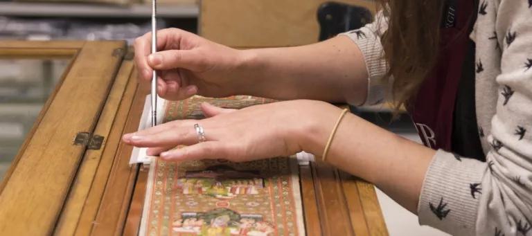 This image is of a conservator working on a scroll.