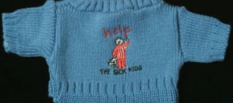 Blue jumper from TASK (To Aid Sick Kids, 1989 - 1992). Text reads: help, THE SICK KIDS