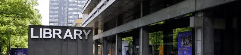A photograph of the Main Library, with the Library sign to the left and the front entrance to the right.