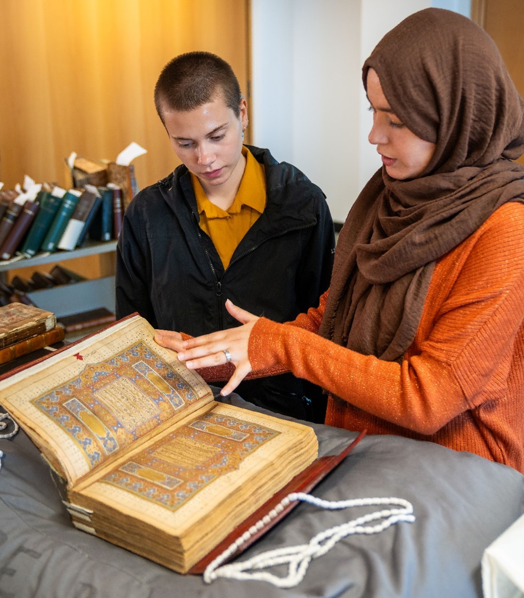 Two people looking at a rare book